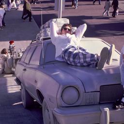 Men lounging on white car.