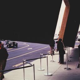 Exterior view, people stand...