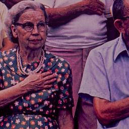 Couple with hands over heart.