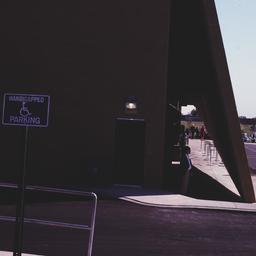 Exterior view, people stand...