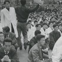A crowd of men in white lab...