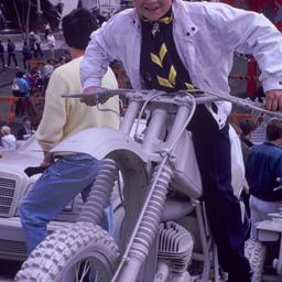 Child riding gray motorbike.