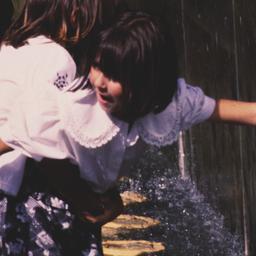 Children touching waterfall.