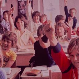 School children raising hands.
