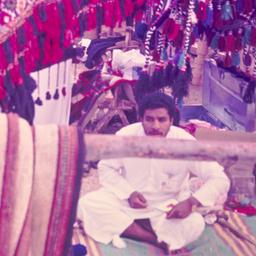 Men sitting on carpets.