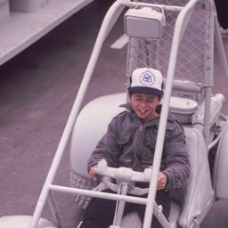 Child riding on gray ATV.