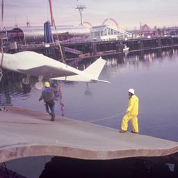 Workers lifting white airpl...