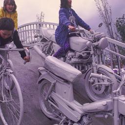 People riding gray bicyles ...