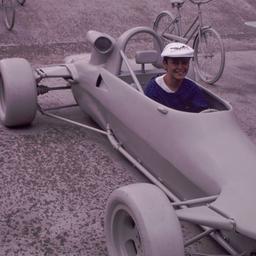 Child riding in gray racecar.