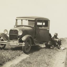 Man Sitting on Rutted Road ...