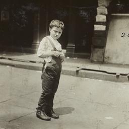 Boy in Overalls on Sidewalk