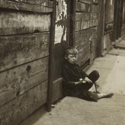 Boy Sitting on Sidewalk