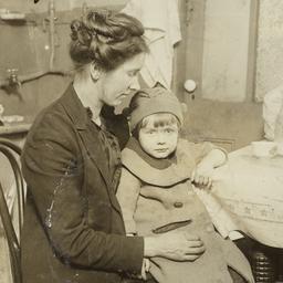 Woman Holding Child Near Table