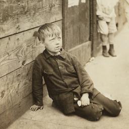 Boy Sitting on Sidewalk nea...