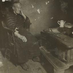 Old Woman in Chair near Stove