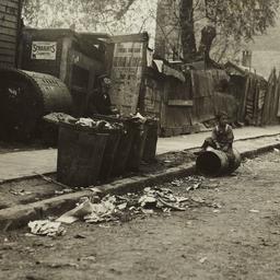 Boy Sitting on Garbage Can