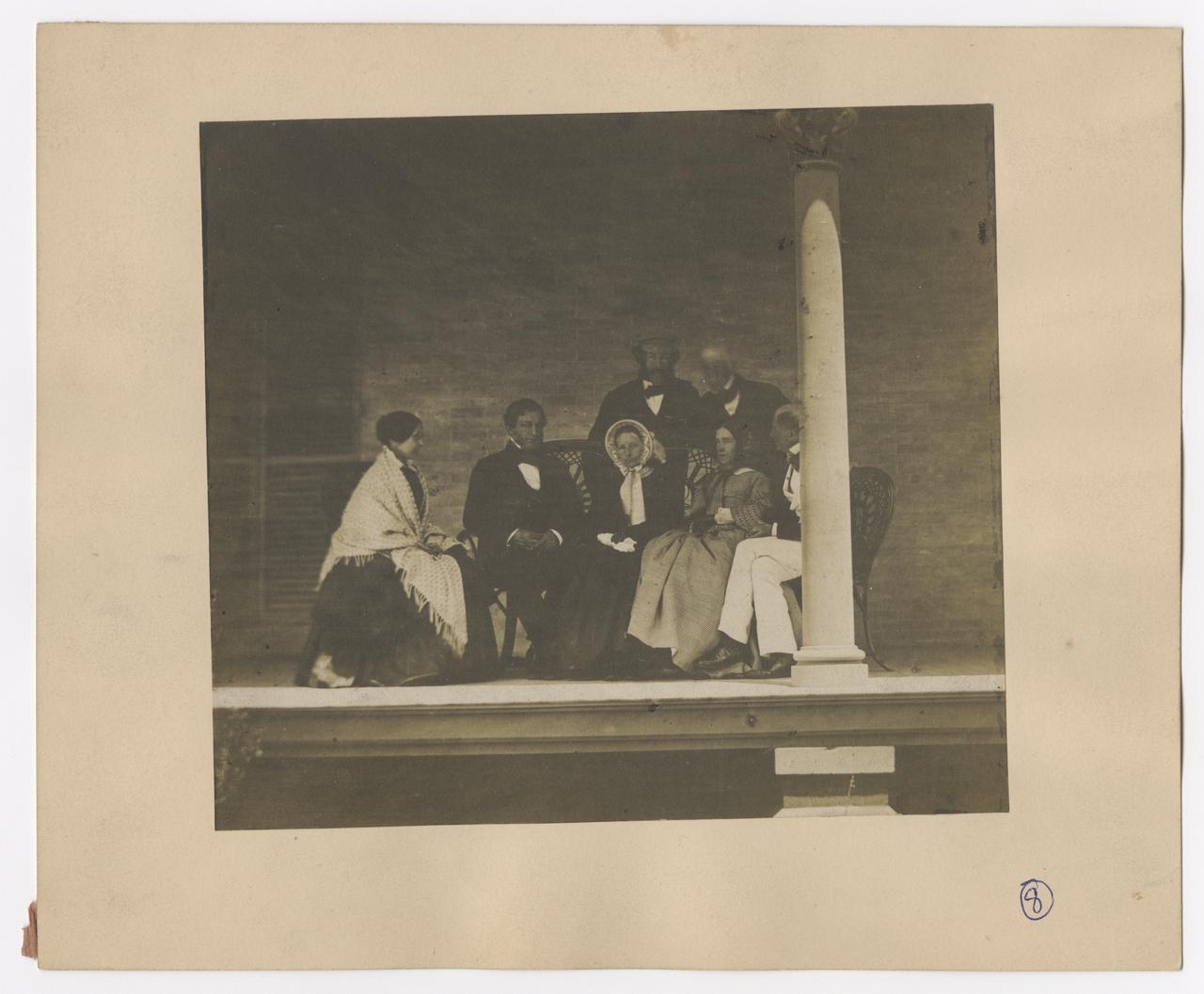 Four men and three women on a porch.