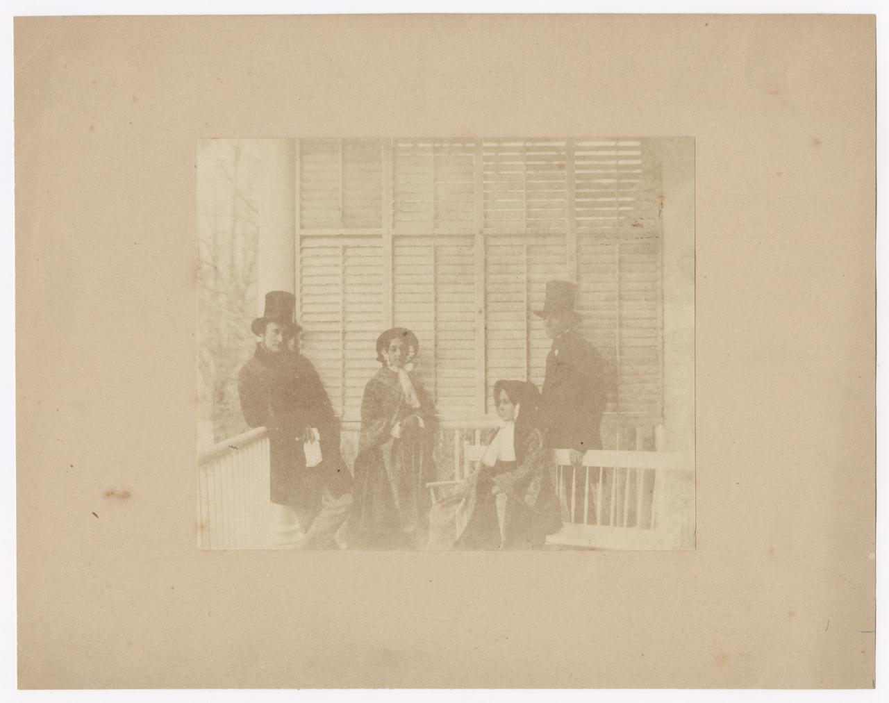 Two women and two men posing in front of a screen. 
