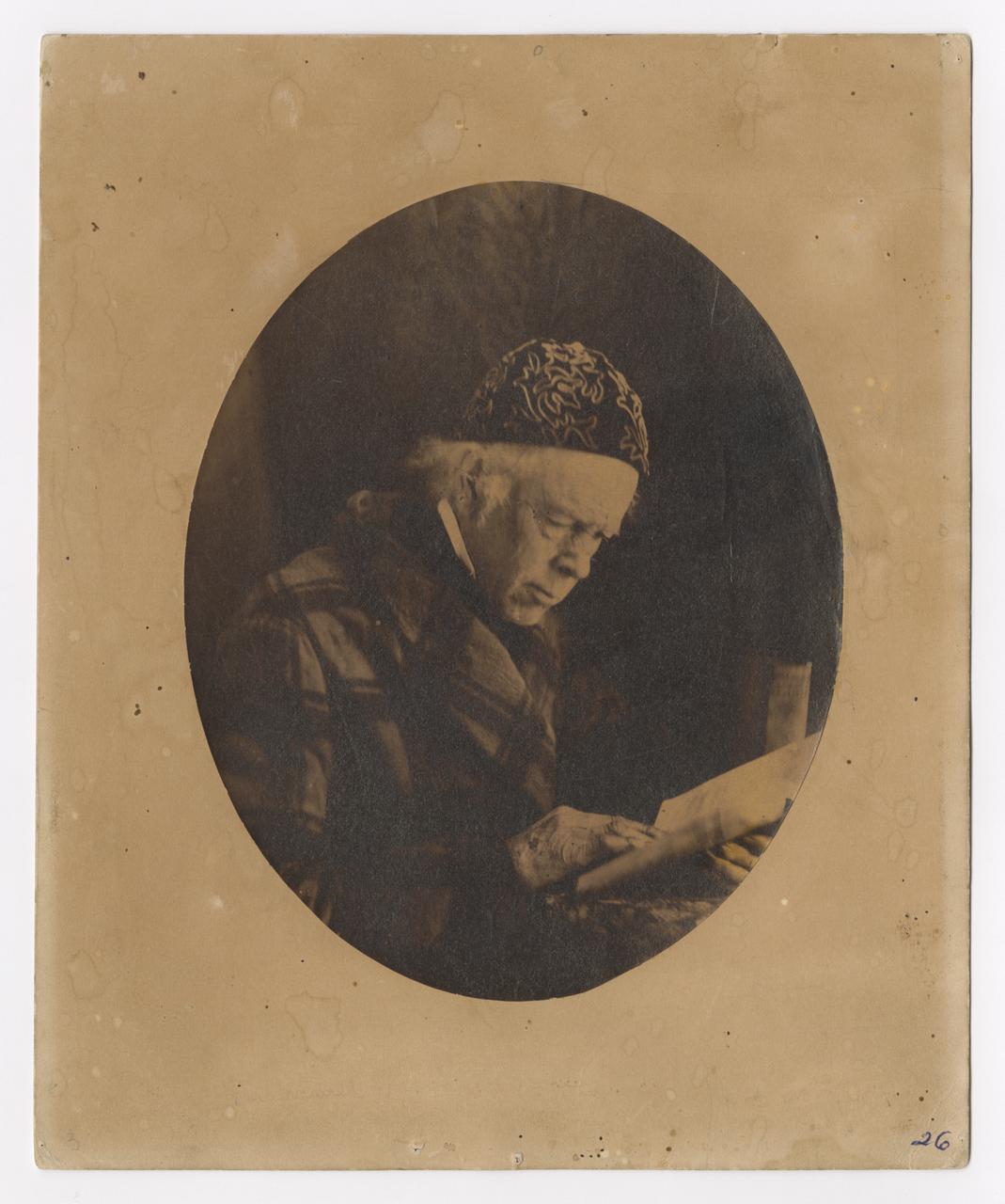 Self portrait of Moore wearing an embroidered hat and reading a book.