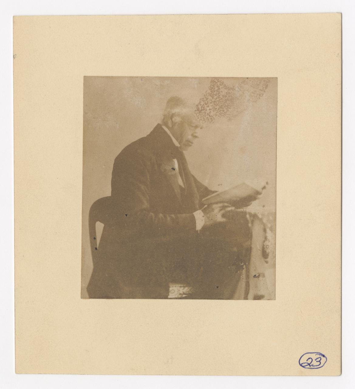 Nathaniel Fish Moore seated and reading a book.