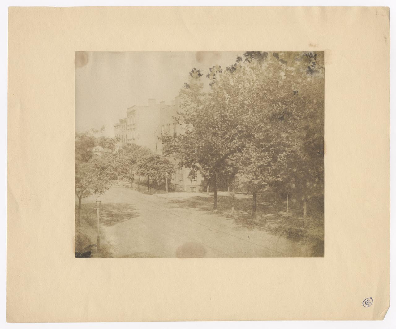 View of Laight and Hudson Streets by St. John's Park, with trees full of leaves.